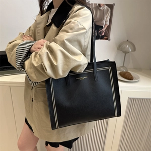 Black leather tote bag with gold studs and shoulder straps for women's daily commute