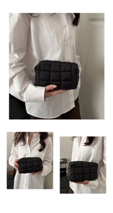 Detail view of black quilted puffer cosmetic bag with premium stitched cloud texture