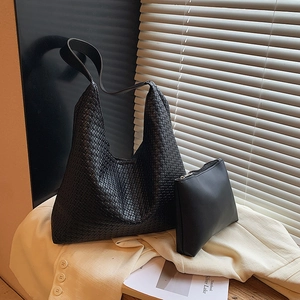 Vue détaillée d'un ensemble de sac hobo noir tressé avec sa pochette zippée assortie