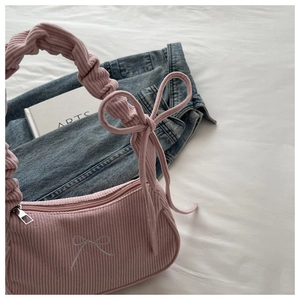 Détail du sac à bandoulière en velours côtelé rose avec nœud brodé et poignée froncée