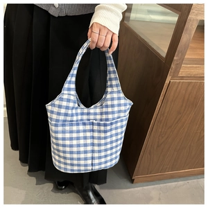 Detail of blue and white gingham canvas tote bag with functional front storage pockets
