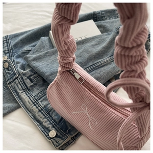 Détail du sac à bandoulière en velours côtelé rose avec broderie nœud et poignée plissée