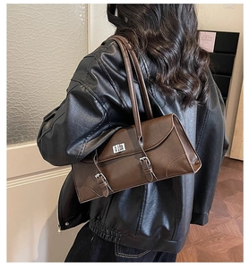 Detail view of a vintage dark brown baguette shoulder bag with silver turn-lock and buckled straps