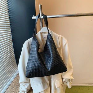 Gros plan détaillé de la texture en cuir tissé noir et de la bandoulière du grand sac cabas