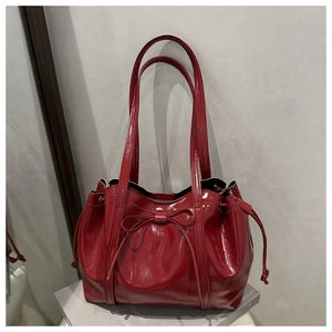 Detail view of the red patent leather bag with bow accent and drawstring design