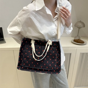 Fashionable corduroy tote bag with red heart pattern shown in a lifestyle setting