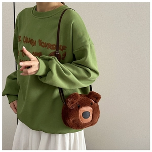 Detailed close-up of a brown plush bear crossbody bag with adjustable strap on a model