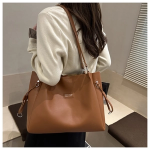 Dettaglio borsa tote grande in pelle marrone con anello in metallo e coulisse laterale