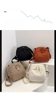Corduroy shell shoulder bags shown in black, orange, khaki, and cream white textures