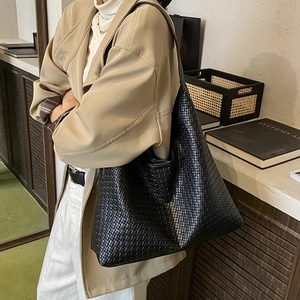 Détail de la texture tissée noire et de la grande capacité de ce sac fourre-tout chic