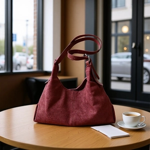 Retro burgundy faux suede hobo shoulder bag on a wooden table in a cafe setting