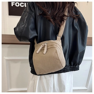 Detail of khaki corduroy crossbody bag with vertical ribbed texture and wide shoulder strap
