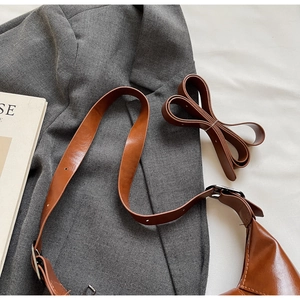 Detail of vintage brown leather saddle bag showing fine stitching and smooth finish