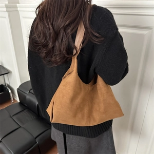 Brown faux suede hobo tote bag featuring a minimalist retro style on female model