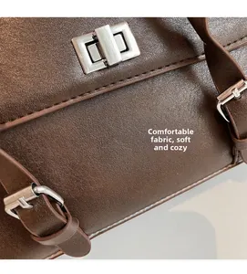 Detailed macro view of brown lychee leather texture and silver metallic twist lock closure