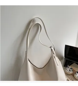 Detailed view of cream leather tote bag hanging on wall with lifestyle props for commute