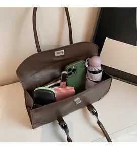 Top view of spacious deep brown tote bag interior with phone, wallet and accessories