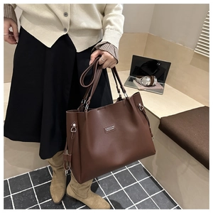 Dettaglio di una grande borsa tote marrone con etichetta fashion e cuciture di qualità