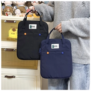 Détail de la housse d'ordinateur portable avec poignées larges et boutons colorés