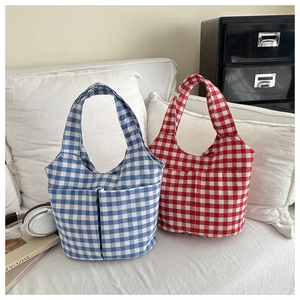 Detailed view of blue and red checkered canvas bucket bags with functional front pockets