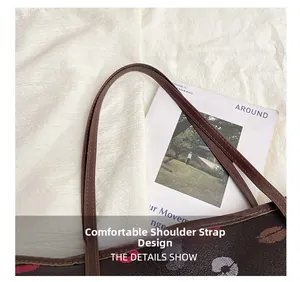 Detailed macro shot of the comfortable synthetic leather shoulder strap on a brown tote bag