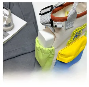 Detail of colorful oxford cloth travel bag showing elastic side pocket with power bank