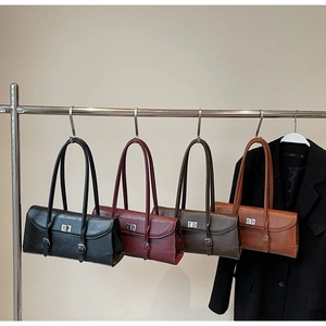 Display of vintage underarm bags in four colors with square metal buckles and long straps