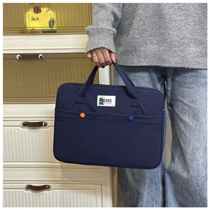 Détail d'une sacoche d'ordinateur bleu foncé étanche avec poches avant et poignée