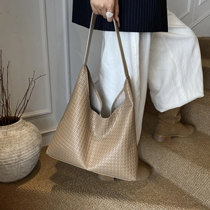 Gros plan sur la texture du sac cabas en cuir tressé sur un escalier vintage