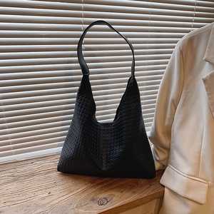 Détail d'un sac Hobo noir tressé avec une texture en cuir serrée et une bandoulière solide