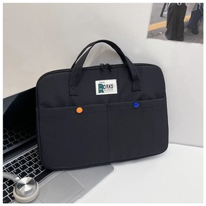 Détail d'une sacoche noire pour ordinateur avec poches avant sur un bureau blanc