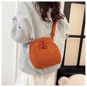 Caramel corduroy shell crossbody bag worn by model showing trendy vertical texture