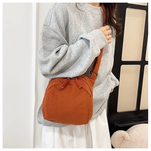 Close-up of caramel corduroy crossbody shell bag with textured vertical stripes and strap