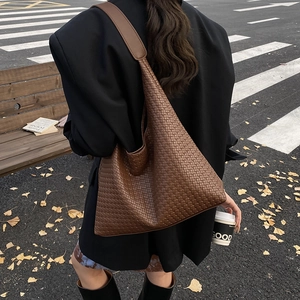 Vue détaillée du sac cabas tressé marron foncé avec texture en cuir de qualité au style hobo