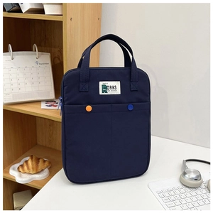 Détail du sac d'ordinateur en toile bleu marine avec boutons colorés et écusson stylé
