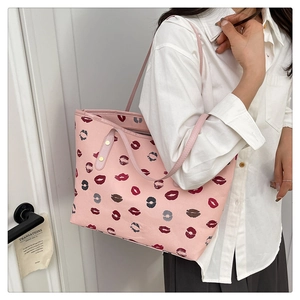 Detail of pink tote bag with lipstick prints, litchi grain texture and metallic rivets