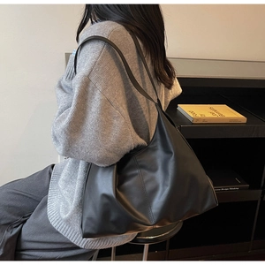 Side view of soft black leather tote bag showing drape and large capacity for commuting