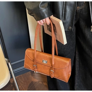 Detailed close-up of brown vintage faux leather baguette bag with silver metal buckle