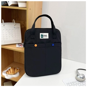 Détail de la sacoche noire pour ordinateur avec logo blanc et boutons sur bureau blanc