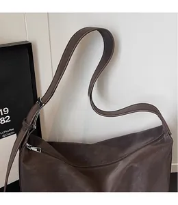 Detailed side view of dark brown oil wax leather shoulder bag with adjustable strap