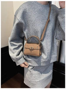 Detail der Mini-Handtasche in Kamelbraun mit Litchi-Leder und goldenem Drehverschluss