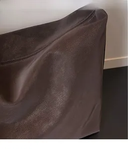 Detail of soft dark brown leather texture and zipper closure on large tote bag