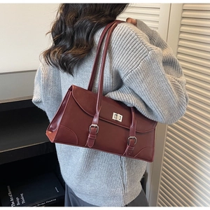 Detail view of the retro wine red baguette bag with dual silver buckles and metal twist lock