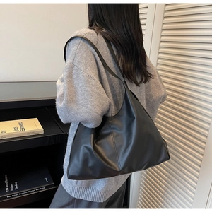 Minimalist black tote bag with soft PU material shown on model for a casual commute look
