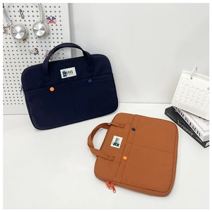 Détail de sacoches d'ordinateur 14 pouces minimalistes en bleu marine et orange avec anses