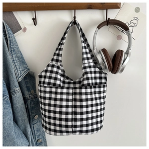 Detail of checkered tote bag with two front pockets and minimalist casual design