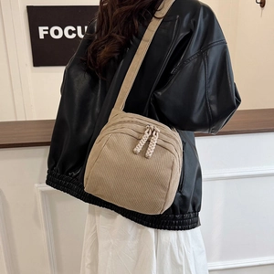 Minimalist khaki corduroy shell crossbody bag with adjustable wide strap and knotted puller