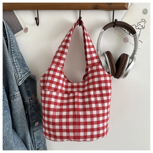Detail of red and white gingham fabric handbag with an external pocket and neat stitching