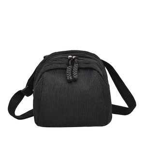Minimalist black corduroy shell-shaped crossbody bag with adjustable wide strap and dual zippers
