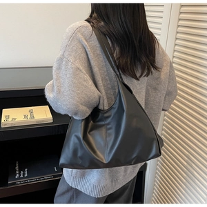 Detail of minimalist black PU leather tote bag with vertical stitching for daily commute